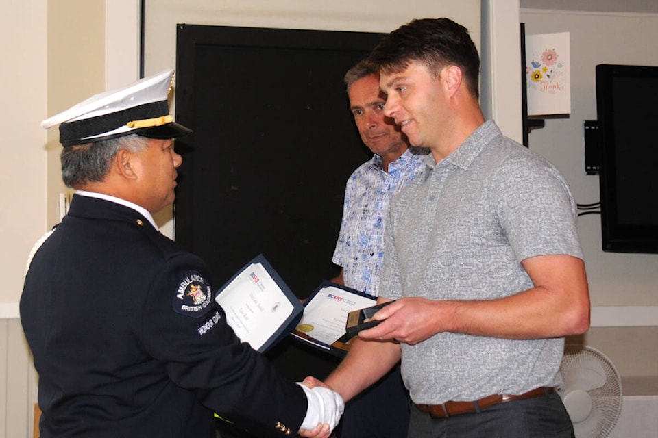 Robbie Jai, left, unit chief for the Parksville Ambulance Station, presents Ed Francoeur, centre, and Tyler Ruel of Port Alberni with Vital Links awards for saving golfer Fred Fredrickson after he collapsed at Alberni Golf Course on Sept. 13, 2020. (SUSAN QUINN/ Alberni Valley News)