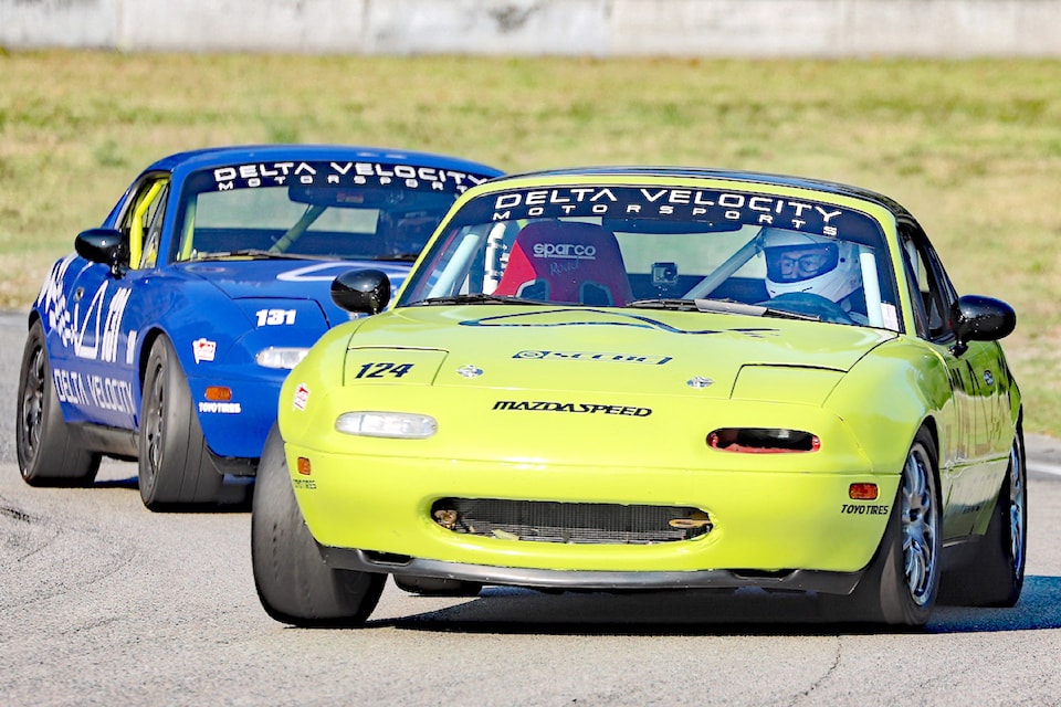 Peter DeVido, at the wheel of his green race-spec Mazda Miata, stayed ahead of a former student of his driving school, Andy Wright in the blue Miata, during a championship race at Mission Raceway Park.  