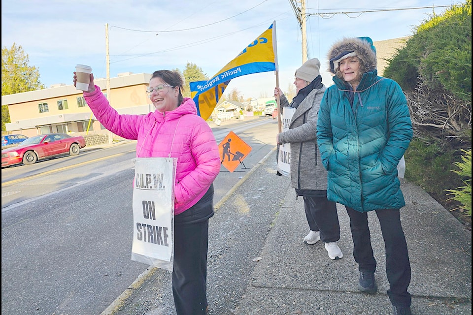 Postal workers waved as passing drivers honked their horns outside the Aldergrove Post Office on 272 St. on Tuesday morning, Dec. 3 as the nationwide dispute entered its third week.