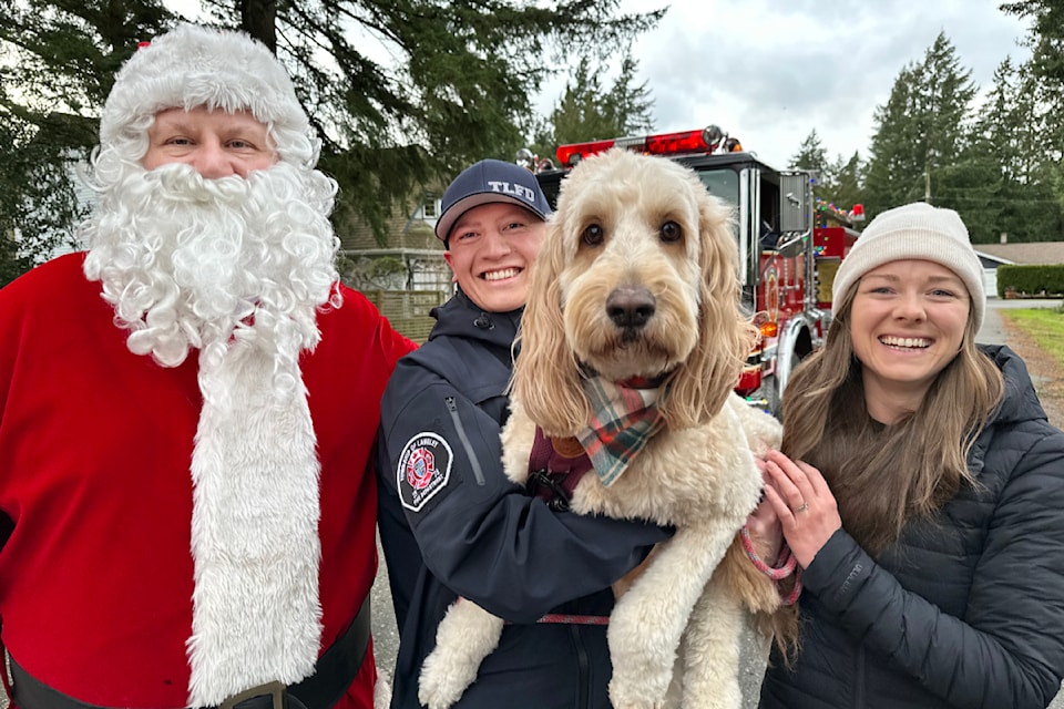 Maple, the dog of firefighter Tanner and Shelby Timmer, wasn't quite sure what to make of the man in red but warmed up to him after a few pats. 