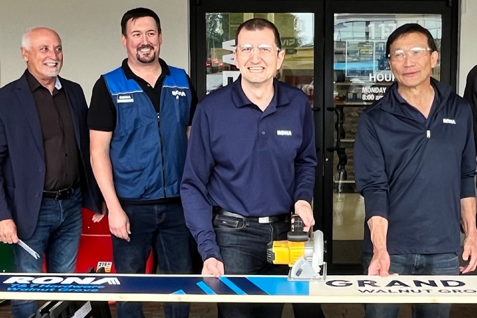 The two Ts of Groupe T&T Hardware,  Michael Trentalance and Al Tsuchinya (centre left and right), were joined many by various Rona affiliates, staff, and a few local politicians an opening ceremony on Thursday, June 27. Instead of a ribbon-cutting, they held a "board cutting" event to mark the launch of their new Rona Walnut Grove Urban store in 91ԭ. 