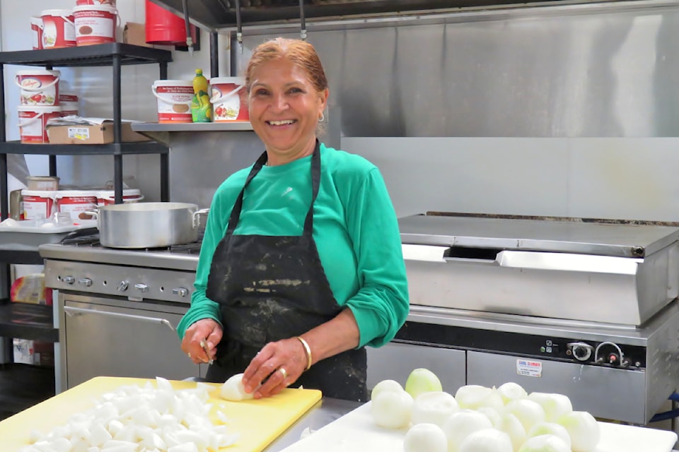 Volunteer Sukhvinder Toor sliced onions in the 91ԭ Meals on Wheels kitchen at the Firehouse Cafe in Aldergrove.