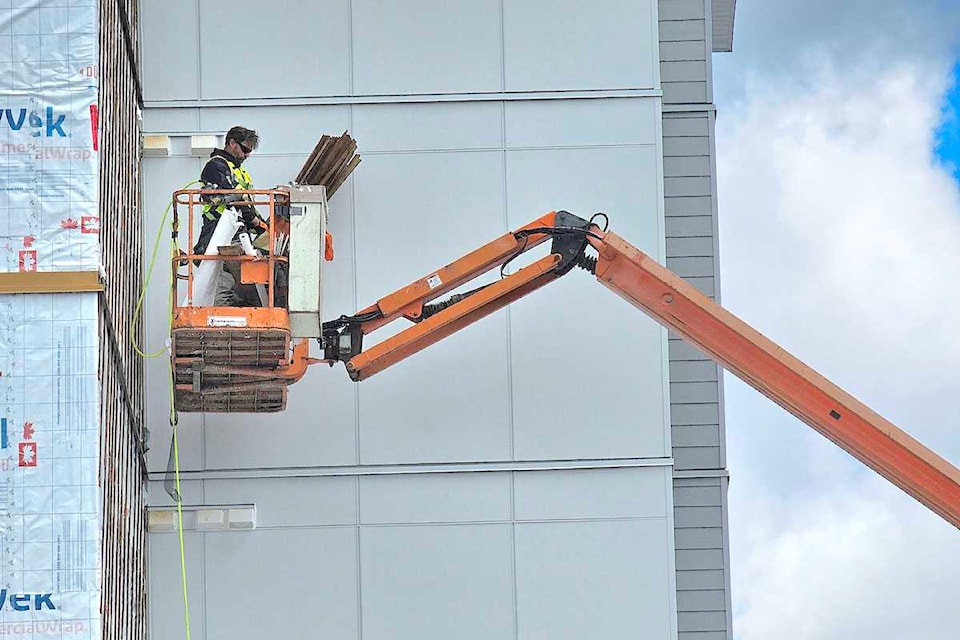 A construction worker was using a lift to access the exterior of an Alder Grove project building in May.