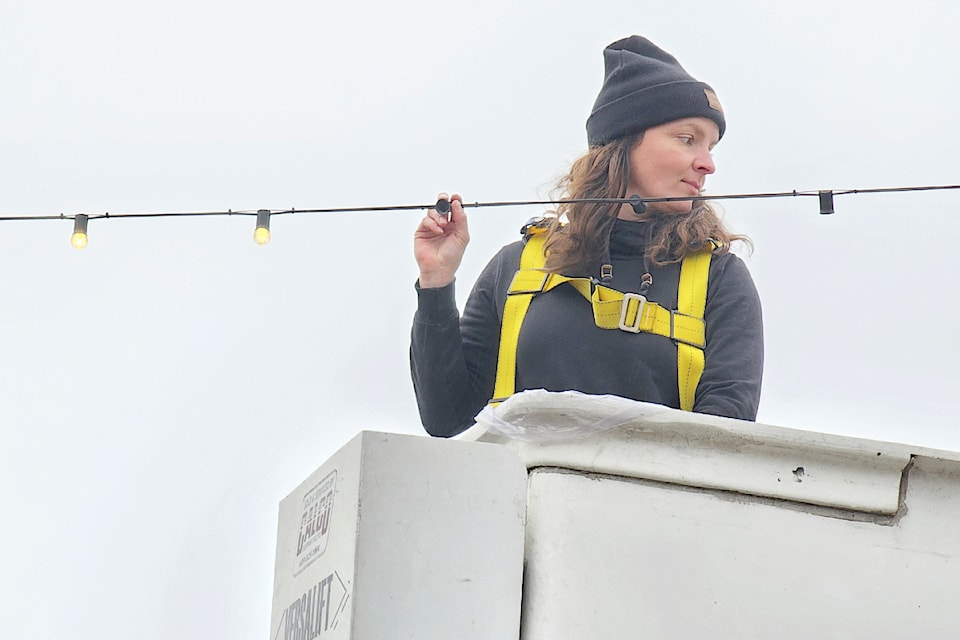 91ԭ City  worker Leah Miller went up in a bucket to replace bulbs on a strand over McBurney Lane. Crews were putting up an estimated 150,000 Christmas lights as December drew near.