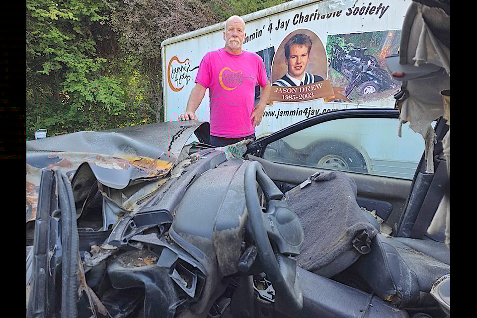 Langley resident Greg Drew with the wrecked car his 17-year-old son Jay was driving. Drew kept it  to use for driving safety presentations.