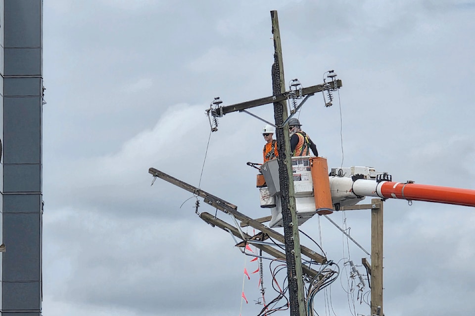 Workers were taking down charred utility poles. Fire crews remained at the scene of a fire that destroyed a nearly completed residential project in  City.