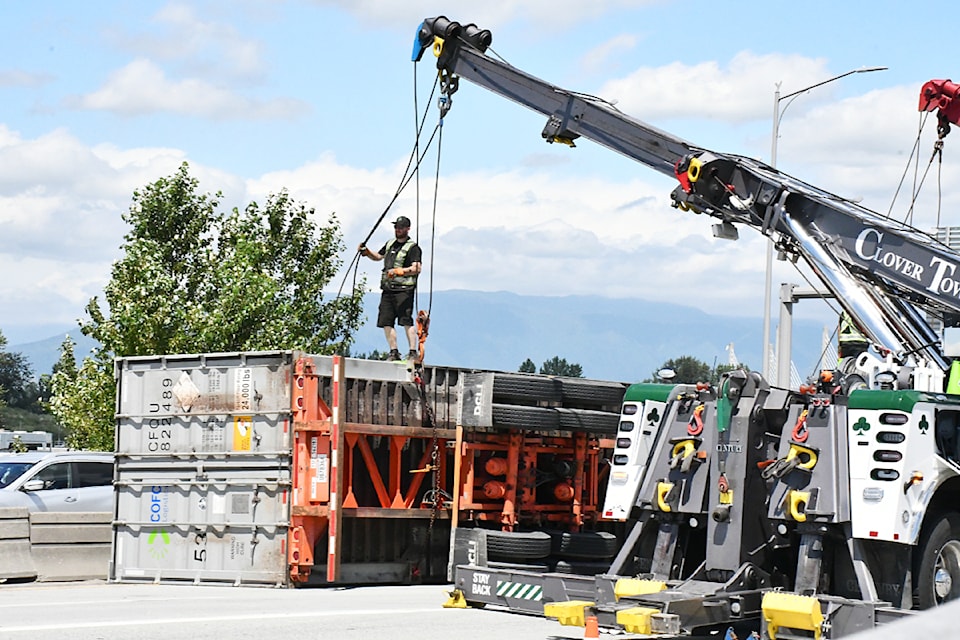 Tow company employees prepared to flip a crashed semi trailer on Monday, July 14 on the Golden Ears Bridge.