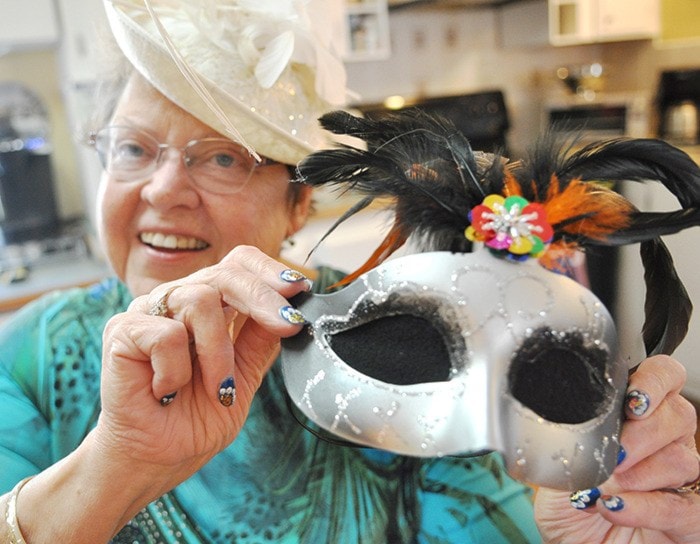 Zosia Ettenberg holds up one of 250 blindfolding masquerade masks that participants wore while “dining in the dark” during a 91ԭ Pos-Abilities Masquerade Gala. (91ԭ Advance Times files)