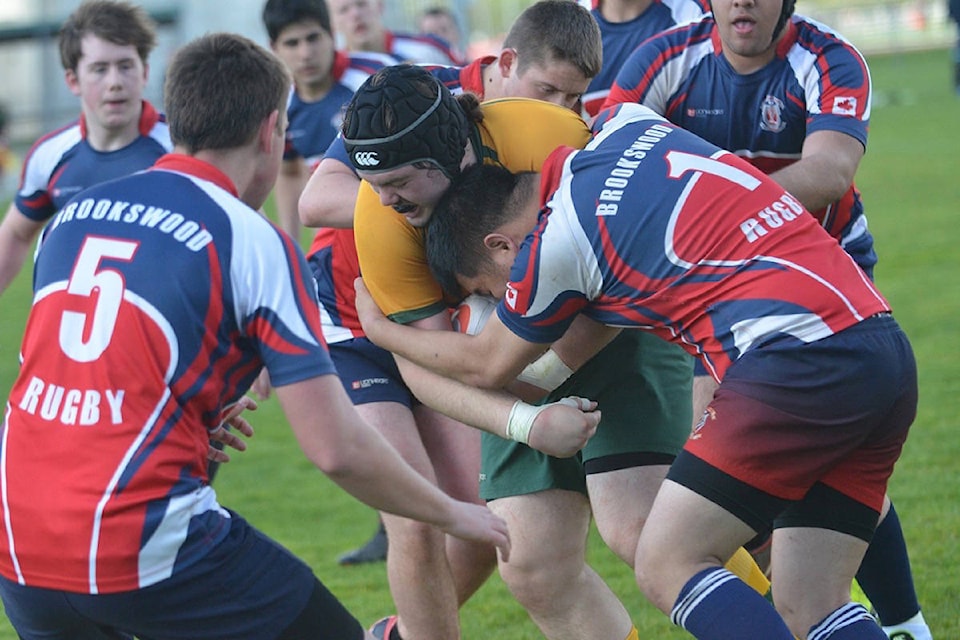 91ԭ Saints’ Cam Smith absorbs the tackle of Brookswood Bobcats’ Philip Lee during senior boys rugby at 91ԭ Secondary last week (April 27). The Saints hung on for the 19-12 victory. Gary Ahuja 91ԭ Times