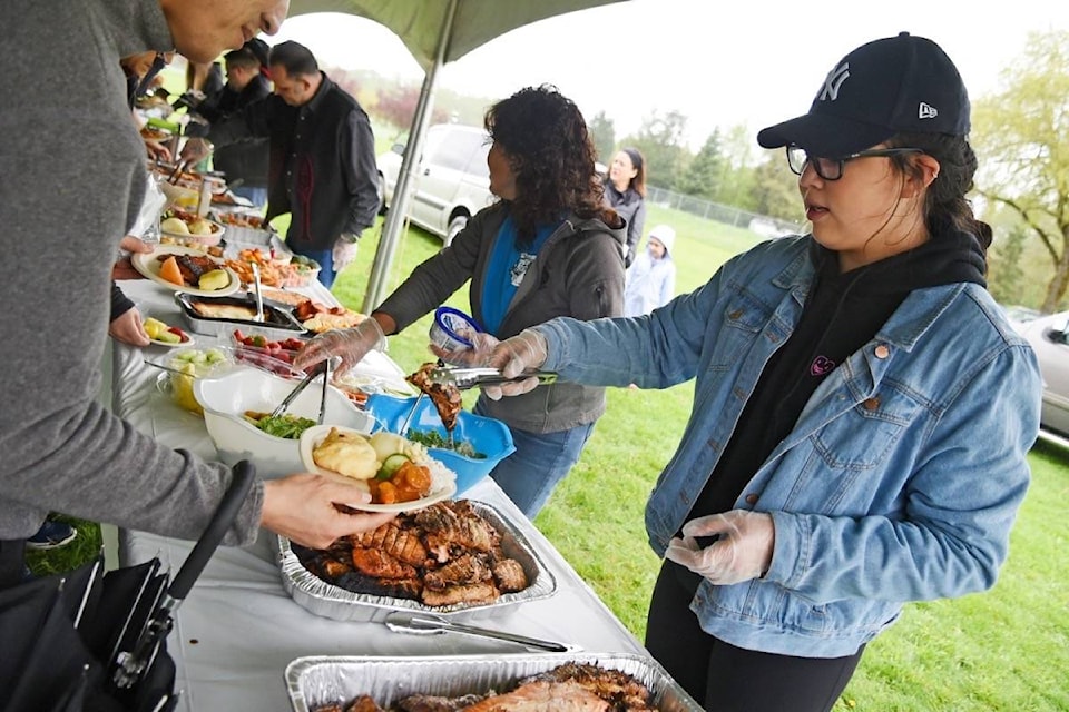 Quantal Kelly-Gabriel, 14, helps dish out the salmon feast during the Kwantlen First Nation First Salmon Ceremony on Friday, May 5. Miranda Gathercole Langley Times