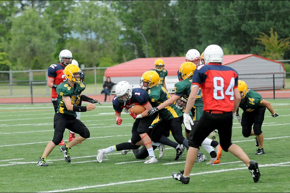 Members of the 91ԭ Saints varsity football team swarm the Samuel Roberts Technical Titans ball carrier during a spring scrimmage at McLeod Athletic Park last week (June 14). Gary Ahuja 91ԭ Times