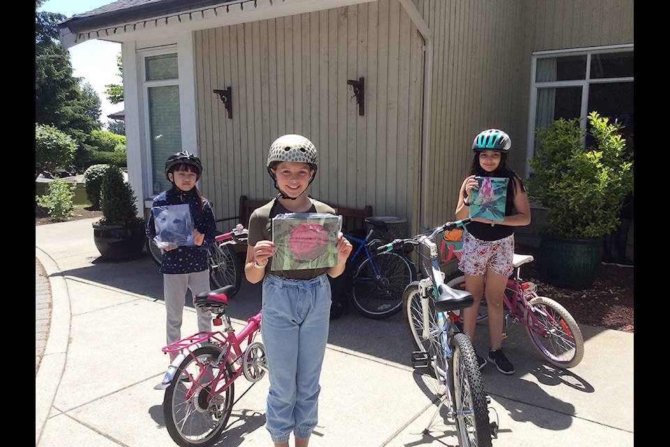 Sunrise Ridge Elementary School students Yurim Lee (left), Ava Demuynck, and Shia Sumra hold up puzzles they delivered to the residents at Zion Park Manor in June. All 22 kids in the girls’ Grade 5 class took photos that were made into puzzles for the residents at Zion Park. (Photo: Stephanie Norris)