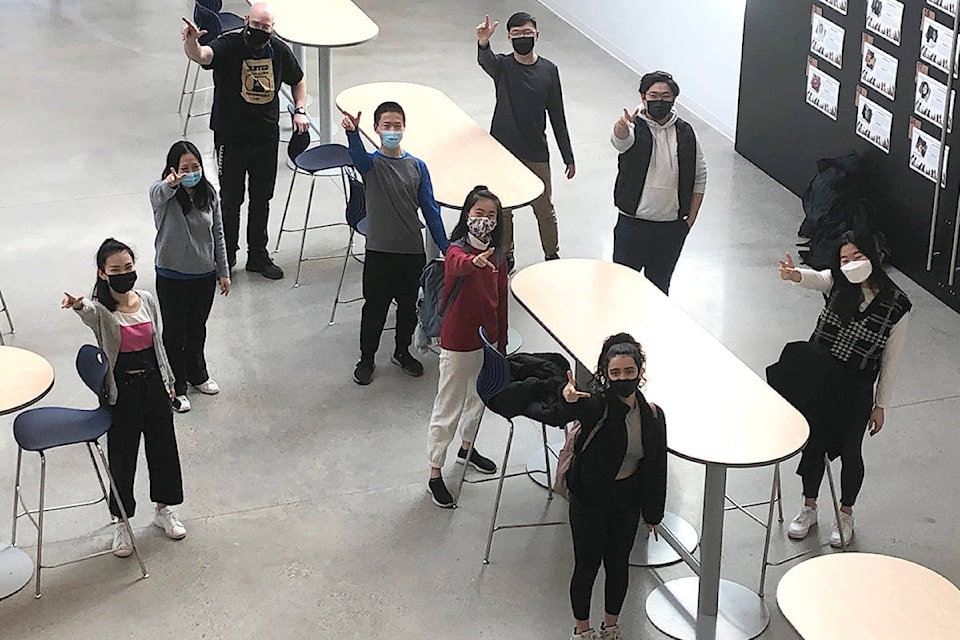 These students from R.E. Mountain alongside teacher Mr. Klassen (top left) were declared the winners of the 2021 UBC Physics Olympics, held virtually on March 6, 2021. The group is illustrating the right-hand rule, using their hands to represent the x,y,z directions. (Setare Maleki/Special to Langley Advance Times)