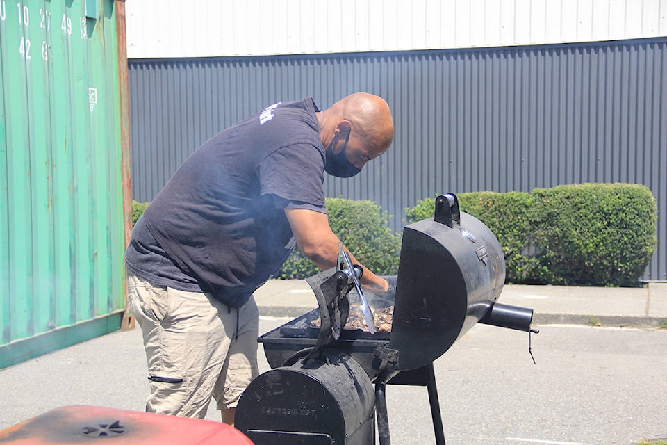 Tai Brown works the grill at Tommie’s Jerk in Cloverdale. The new Jamaican eatery opened up a few months ago in space next to the Cloverdale Community Kitchen. (Photo: Malin Jordan)