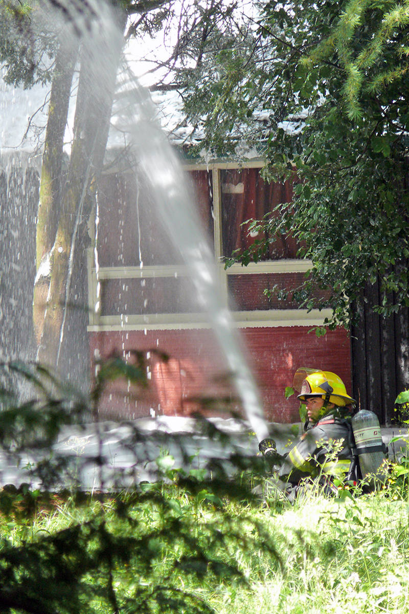 25638318_web1_210626-LAT-CondoFire-hosing-down-house_1