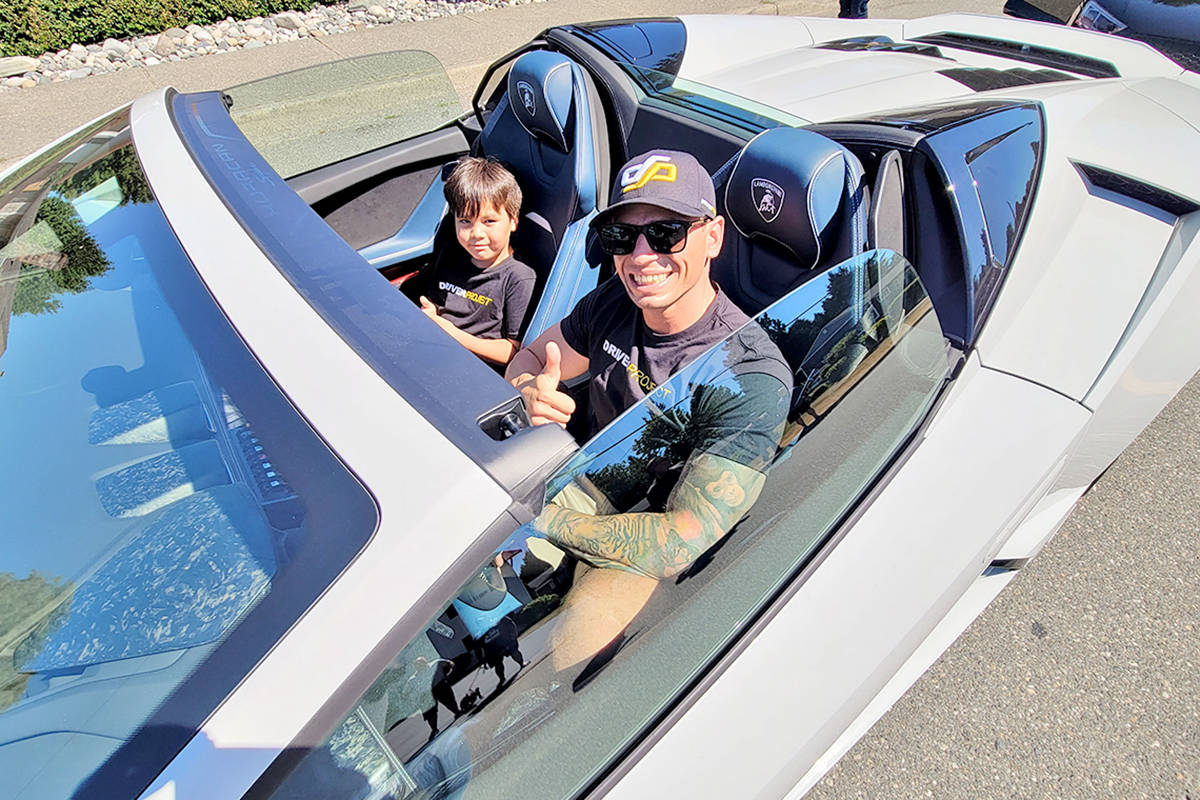 A volunteer driver gave a thumbs-up as a fleet of supercars paid 91原创 City teen Alyssa Anderson a visit on Sunday, July 25, as part of the Drive Project that aims to bring a little motorized magic to special kids. (Dan Ferguson/91原创 Advance Times)