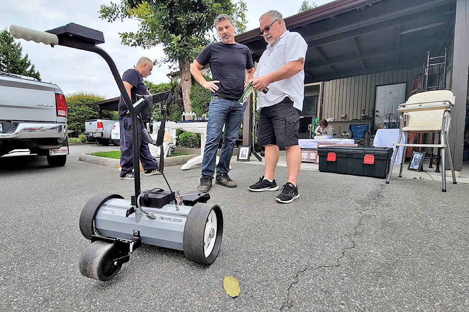 A seller demonstrated a remote-controlled golf bag carrier to a prospective buyer. More than 500 bargain hunters are estimated to have taken part in the third annual giant Aldergrove garage sale held on Saturday, Aug. 22. (Dan Ferguson/91ԭ Advance Times)