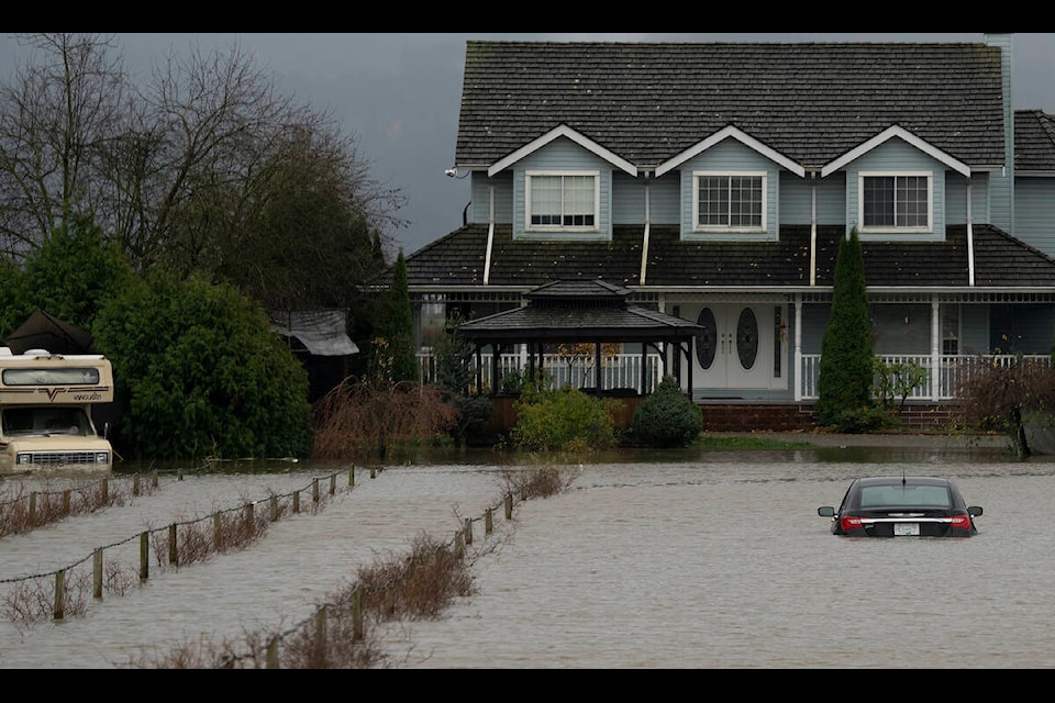 A vehicle is submerged in flood waters along a road in Abbotsford, B.C., Monday, Nov. 15, 2021. THE CANADIAN PRESS/Jonathan Hayward