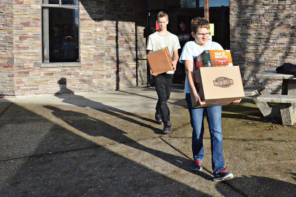 Credo Christian High School students, such as Ayden van den hoven and Russell deBoer, sorted and packed donations Friday. (Heather Colpitts/Langley Advance Times)