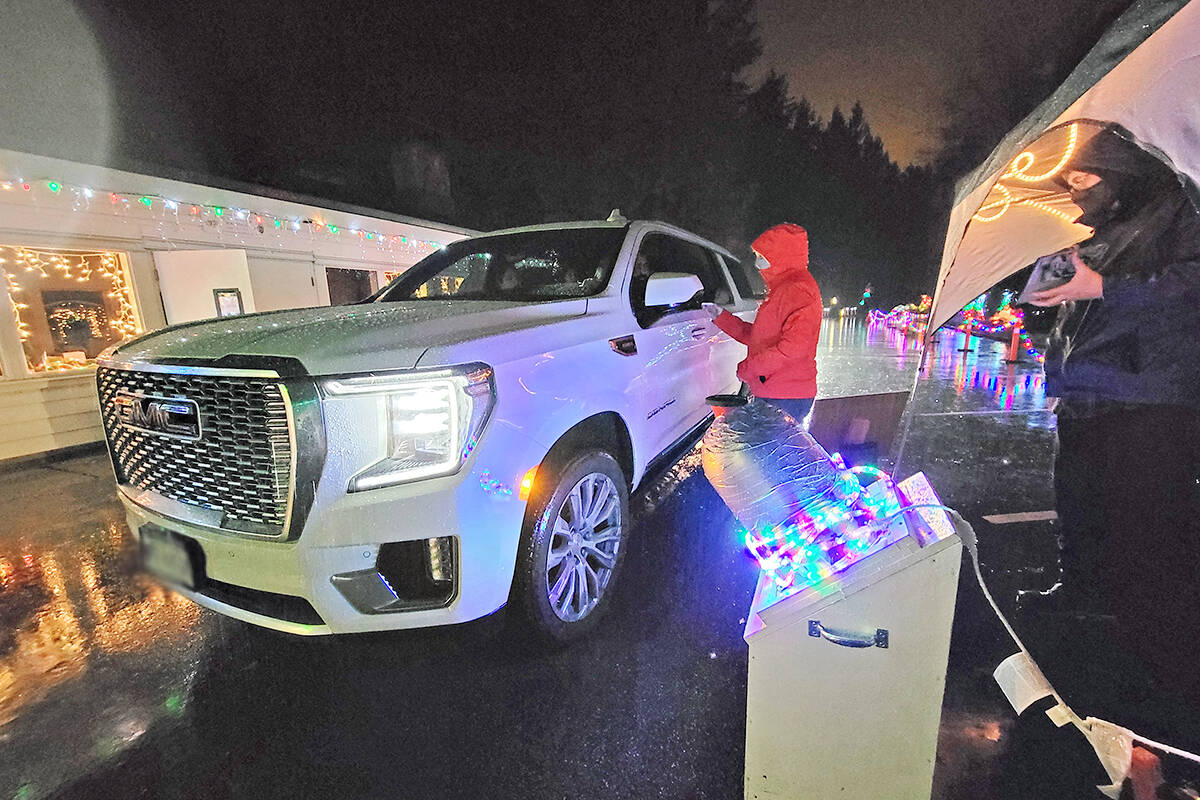 A visitor makes a donation. Christmas in Williams Park runs from 5 p.m. to 9 p.m. at 68th Avenue and 238th Street until Dec. 19. (Dan Ferguson/Langley Advance Times)