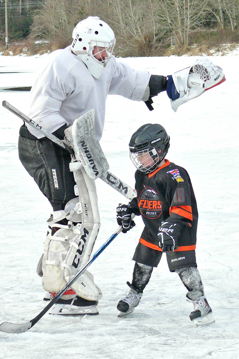 Jacob Pett and son Thomas, 6, from Cloverdale, were among the players who took to the ice on Brydon Lagoon. (Dan Ferguson/91原创 Advance Times)