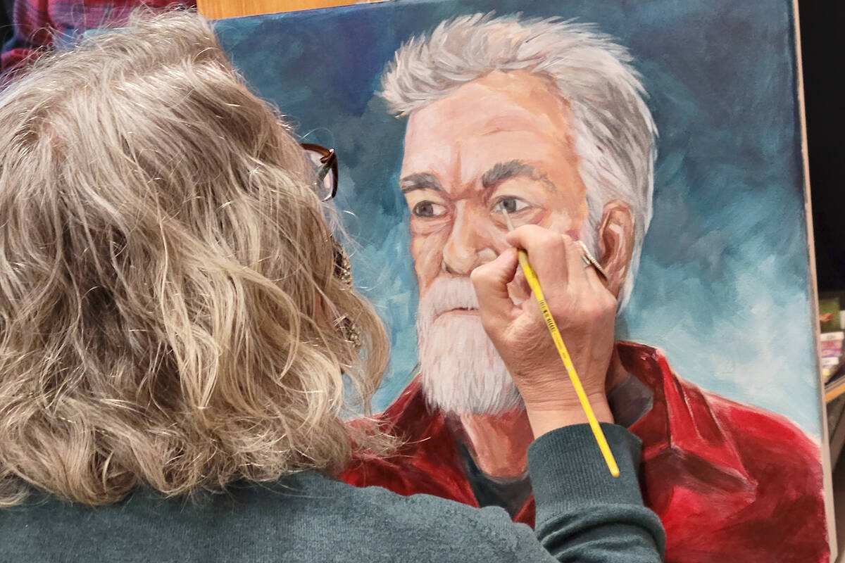 An artist applied finishing touches to a portrait of musician Darryl Klassen at the Aldergrove Kinsmen Centre on Sunday, Feb. 27. Langley Arts Council held a B.C. wide portrait and live painting competition. (Dan Ferguson/Langley Advance Times)