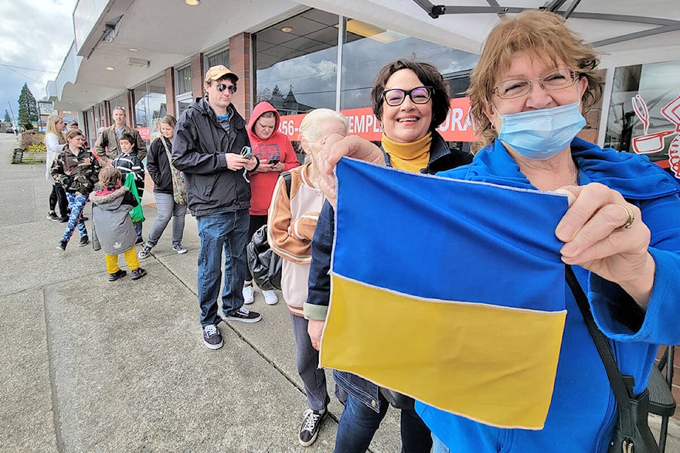A Ukraine flag was displayed by a supporter waiting in line at Veronica’s Gourmet Perogies on Saturday, March 19. Owner Veronica Cave raised funds for the besieged country by selling deep fried apple cinnamon perogies. (Dan Ferguson/91ԭ Advance Times)