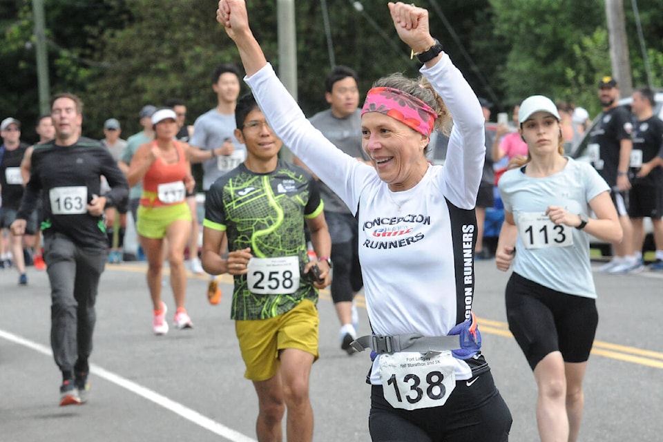 An exuberant Ximena Garces (138) was second in the 50-59 women’s division at the Fort 91ԭ Half Marathon and 5K race presented by Peninsula Runners and Garrison Running Co. on Sunday, July 10. (Dan Ferguson/91ԭ Advance Times)