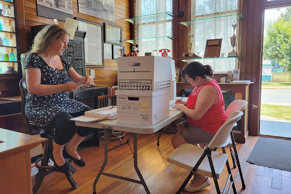 Volunteer Emily Morgan and Brenda Haid, vice-president of the Alder Grove Heritage Society, sort through donated photos from the Aldergrove Star at the museum on Sunday, July 24. On Saturday, August 13, the museum will host Heritage Day from 11 a.m. to 4 p.m. (Dan Ferguson/Black Press Media)