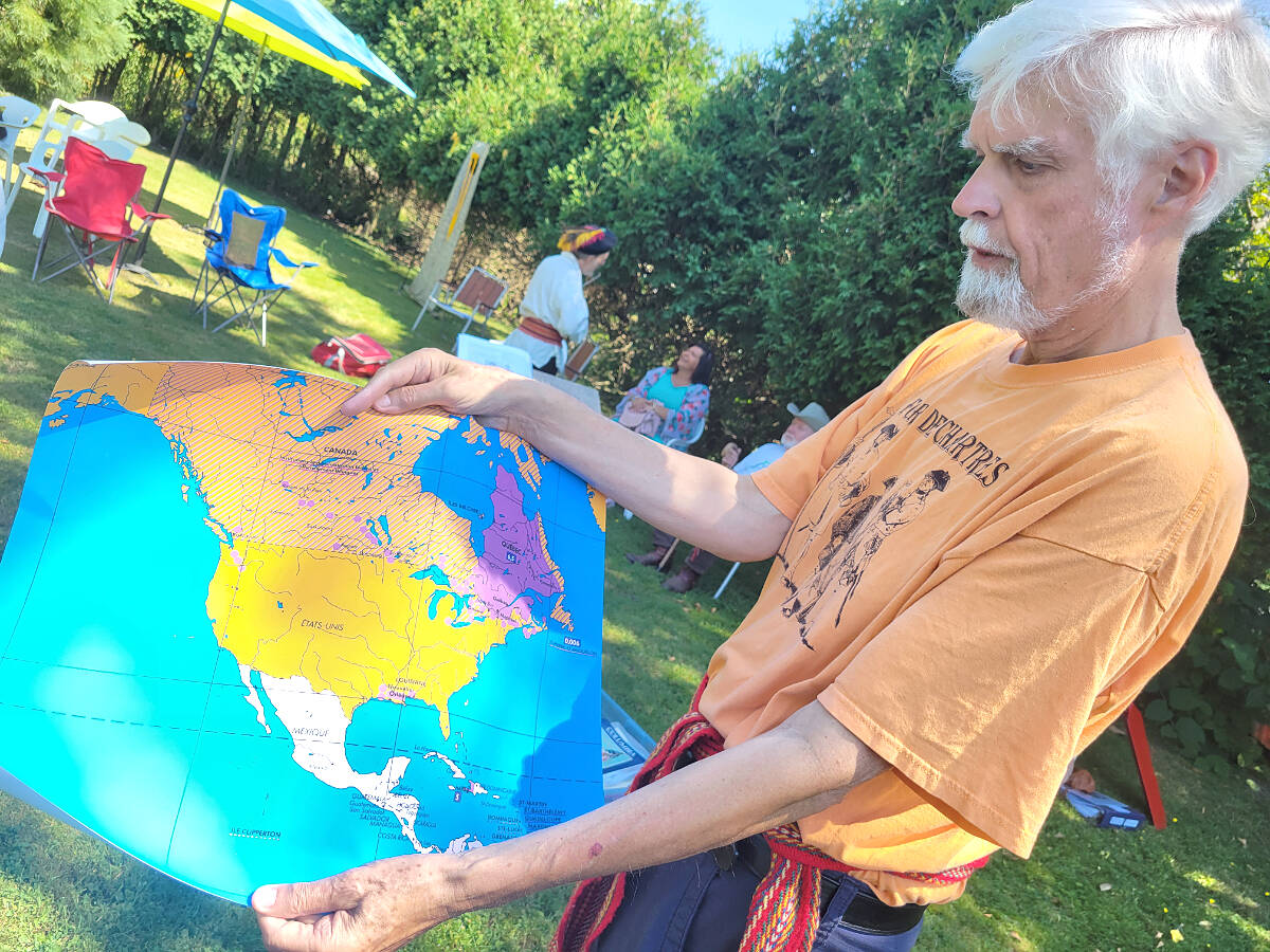 Historian Robert Foxcurran unrolled a map that show how far early French explorers travelled and settled, part of an overlooked period of history. He was a featured speaker at the historic picnic held outside Michaud House in Langley City on Sunday, July 31. (Dan Ferguson/Langley Advance Times)