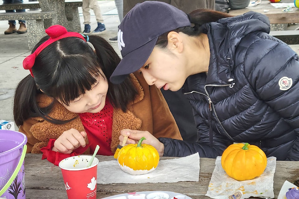 Doyeon Lee, 9, and mom Jiaye Son took part in the ‘Hi Neighbour’ gourd painting event at the Willoughby park picnic shelter on Saturday, Oct. 29, one of a series of United Way-backed events designed to bring people together to make connections. (Dan Ferguson/Langley Advance Times)