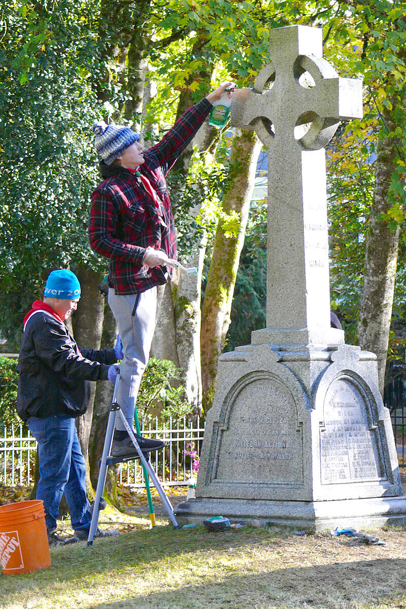 Adrian Holloway steadied a stepladder for his son Evan, who was stretching to clean the higher parts of the cenotaph at the Fort 91原创 cemetery on Saturday, Nov. 5, to prepare for Remembrance Day. (Dan Ferguson/91原创 Advance Times)