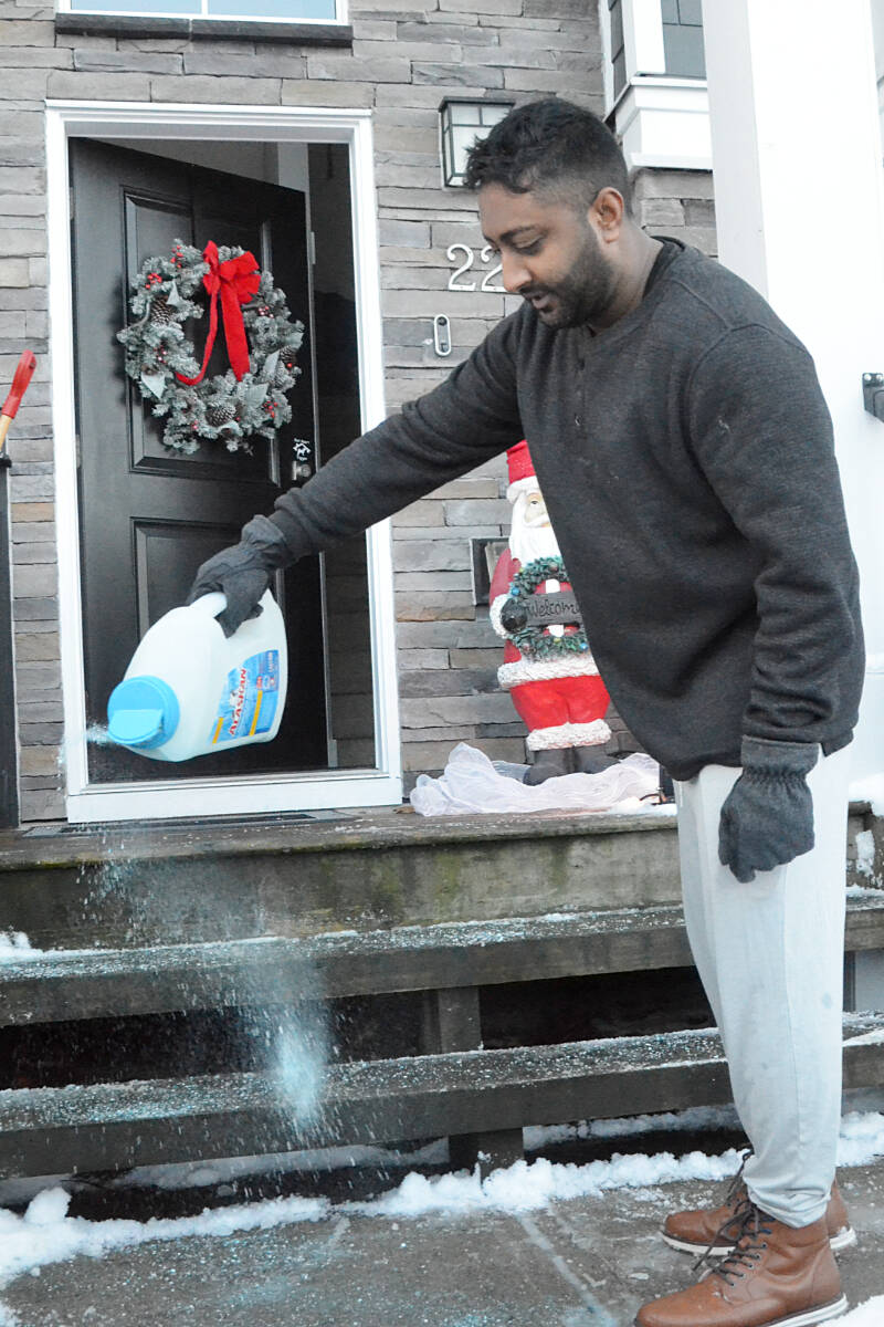 Jeff Singh spread de-icer on his steps in Willoughby on Wednesday morning. He said fortunately, he works from home. (Matthew Claxton/91原创 Advance Times)