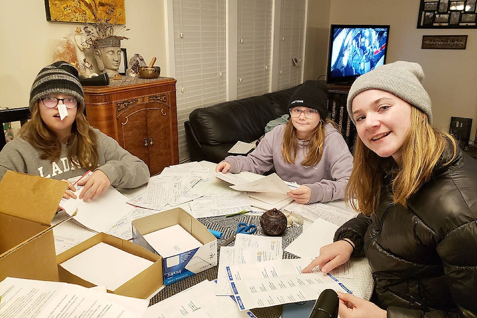 Young volunteers JayLynn Jones, Marissa Falk and Ali Falk helped sort for delivery 3,700 Christmas cards created by Langley students for seniors and other people deserving a holiday boost. (Special to Langley Advance Times)