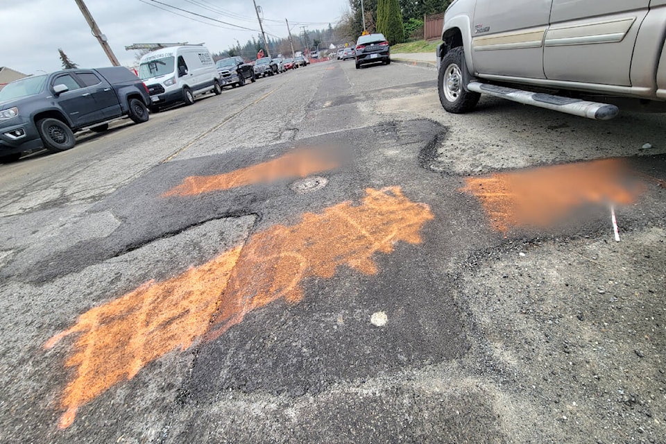 Frustrated by the bumpy results of road patching along 198th Street near 53rd Avenue in 91ԭ City, someone spray painted the pavement with negative comments. Someone else tried to paint over them. (Dan Ferguson/91ԭ Advance Times)