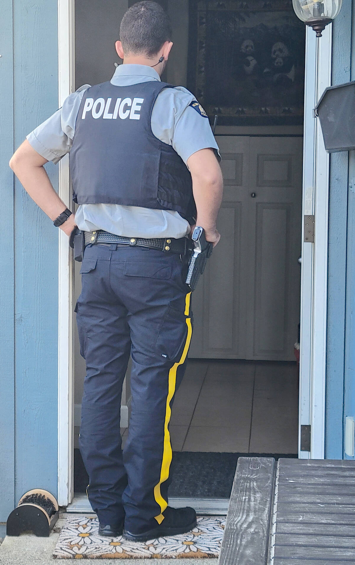 Const. Cole Wilson waits for an occupant of an Aldergrove home to come to the front door. While the matter under investigation was considered to be relatively routine, Wilson told the Langley Advance Times those kinds of calls can suddenly become serious. (Dan Ferguson/Langley Advance Times)