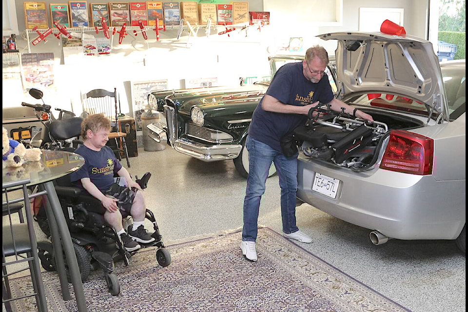 As Doug Penner looked on, his dad Cam unveiled the portable wheelchair that will fit in the trunk of his race car, a 2006 Dodge Charger RT at the April 29 reveal. (Theresa Wiebe/Special to 91ԭ Advance Times)