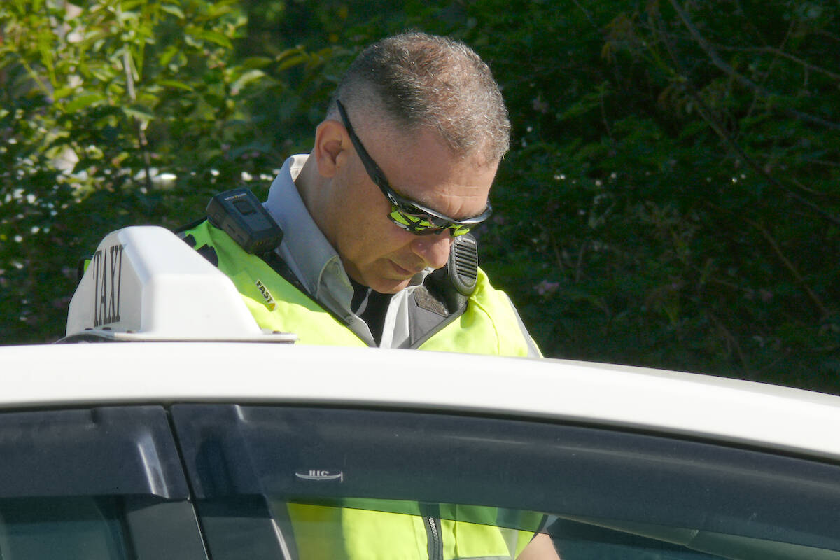 An officer pulled over a cab driver for a chat about road safety regulations Monday, May 15, in Aldergrove. It was the start of the 13th annual Cone Zone campaign, which aims to raise awareness of the risks workers face in roadside work zones. (Dan Ferguson/Langley Advance Times)