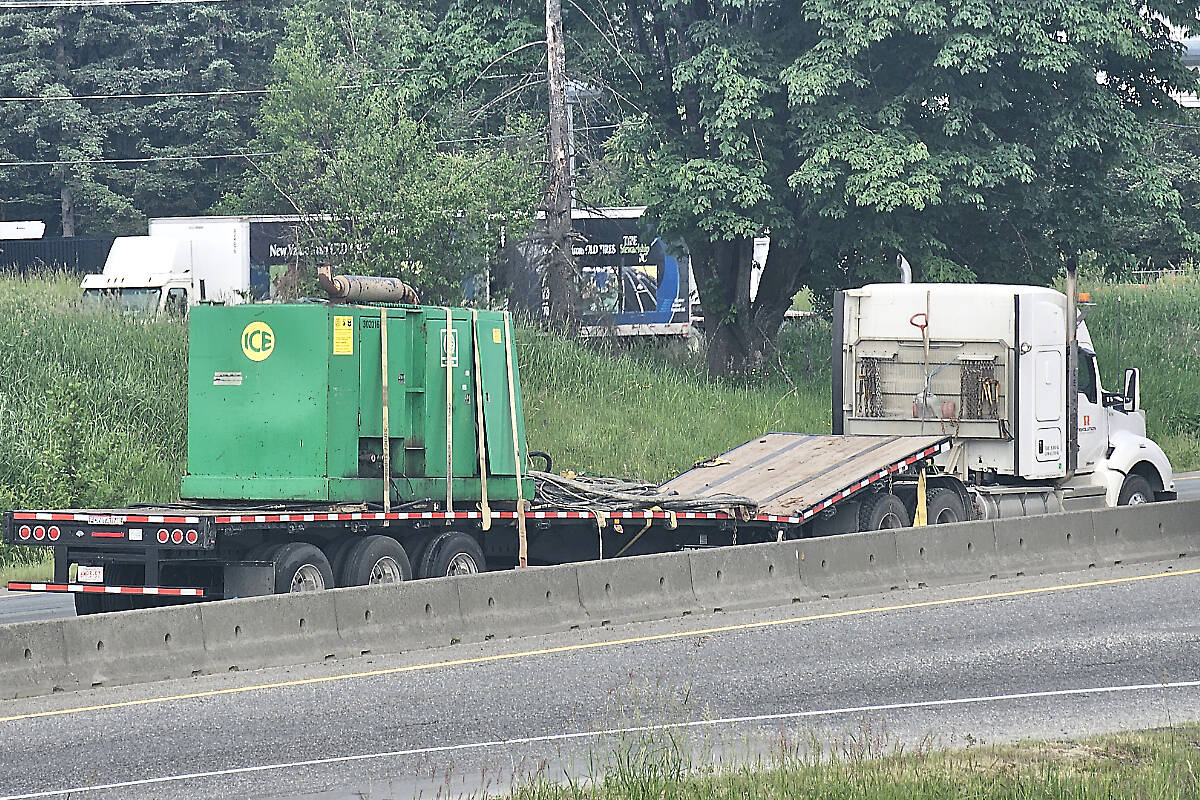 Highway #1 westbound at the 264th Street overpass in Aldergrove was closed for several hours Monday morning, May 29, after a flatbed semi truck failed to clear the overpass, knocking a piece of heavy equipment on to the road and damaging the trailer. Engineers determined the overpass was safe to use. (Dan Ferguson/Langley Advance Times)