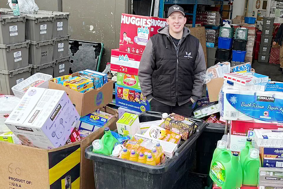 Cody Woolford from Vulcan Mechanical is surrounded by 1,980 pounds of perishable and non-perishable products. 