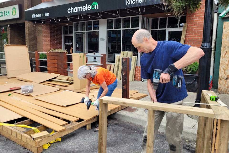 Owners repair the curbside patio at the Chameleon after a fire on June 8, 2024.