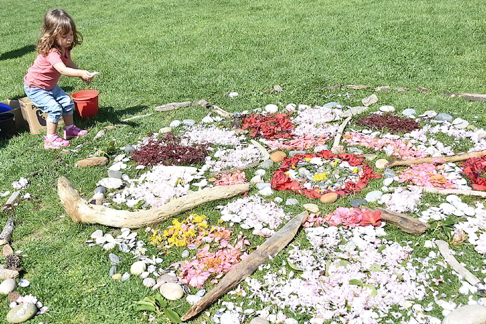 Julia Morrow, 2, works on an interactive nature mandala at the Celebrate Earth Day festival in Maple Ridge on Saturday, April 26. 