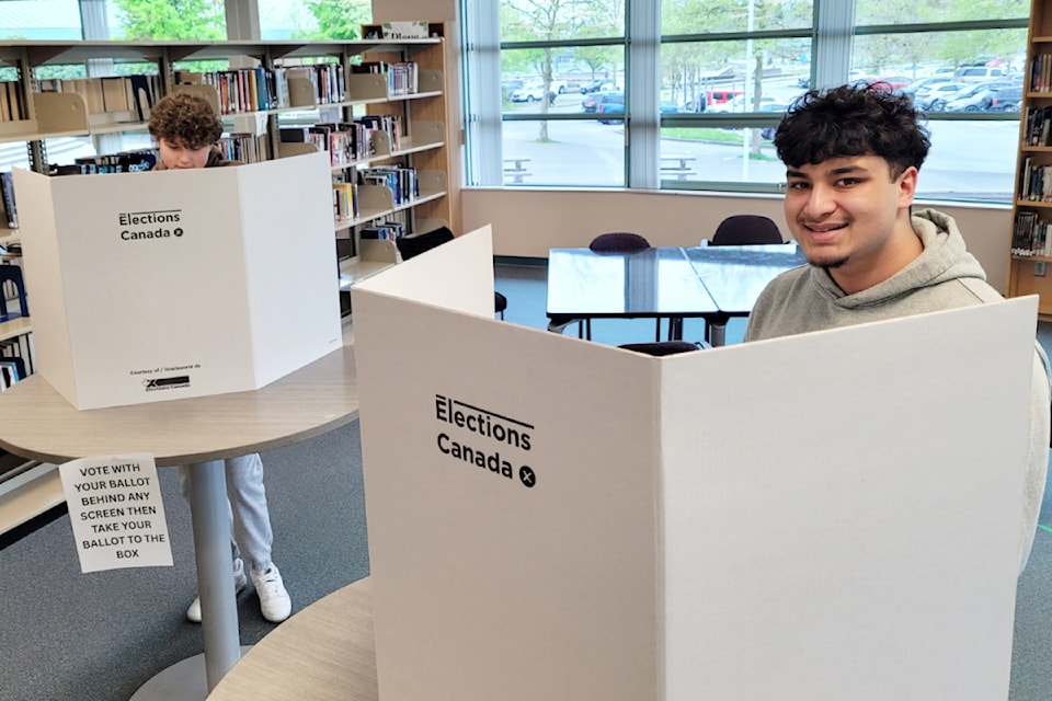George Lindquist (left) and Mohammed Tuma mark their ballots.