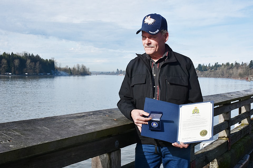 Delbert Soles, who rescued a woman from the choppy waters of the Fraser River in November, holds a commendation and medal he received from the Ridge Meadows RCMP.