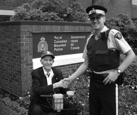 Earl Harmata with his scooter and RCMP Constable Jordan Mullen.