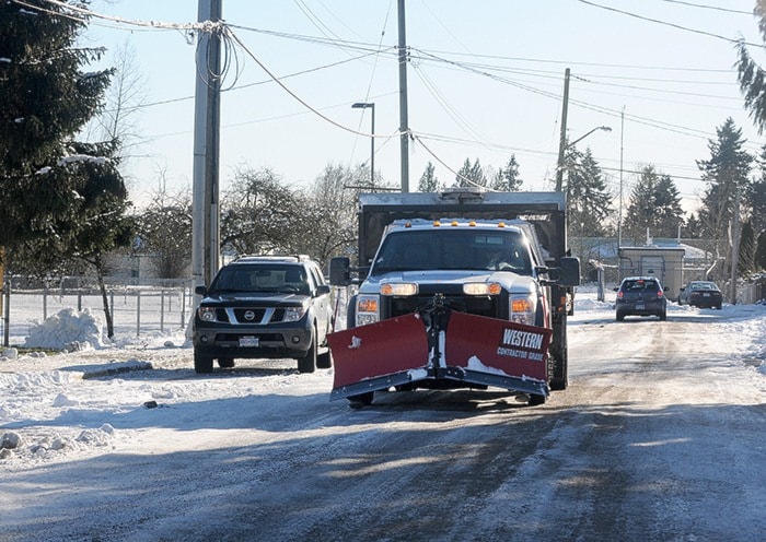 City of Maple Ridge snow plow drives along 231 Street on a busy day.