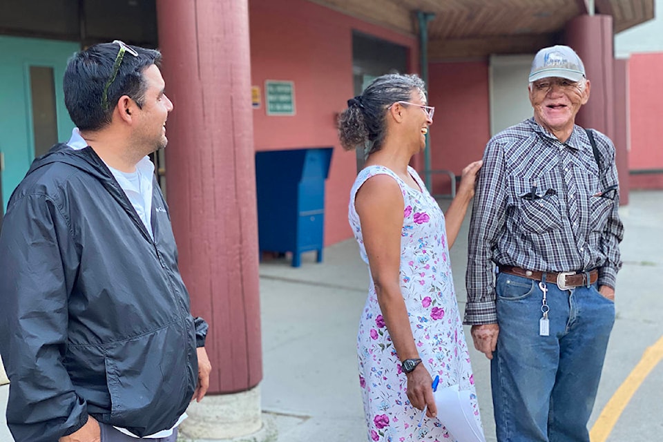 Ulkatcho First Nation councillor and community health representative, Anthony Sims, waits as First Nation Health Authority community engagement coordinator Jamie Tanis says goodbye to an Ulkatcho elder who evacuated his community Wednesday, July 14, by helicopter to Puntzi, then by bus to Williams Lake and on to Prince George. Sims was travelling with his members to PG to assist them. (Angie Mindus photo - Williams Lake Tribune)