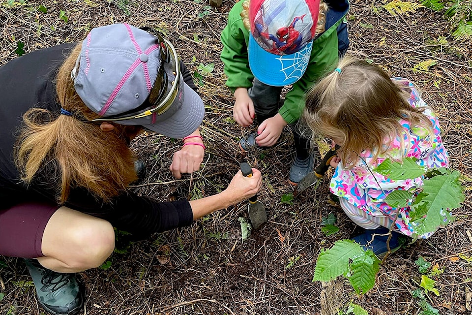 A family planting a native plant at the City’s park restoration area in Hoffman Park. (City of Pitt Meadows/Special to The News)