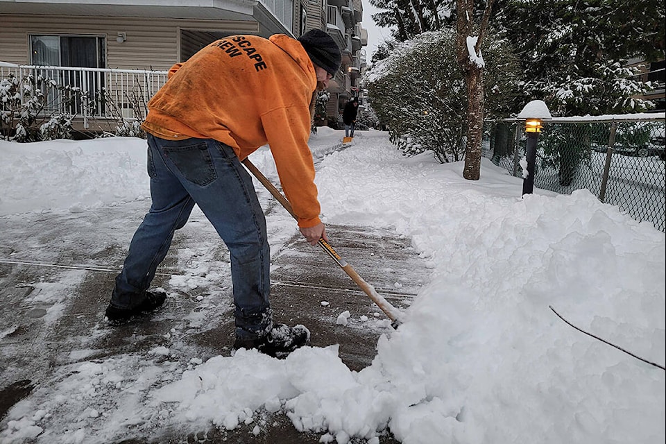 Tyler Russell clears snow at Cottonwood Place. (Neil Corbett/The News)