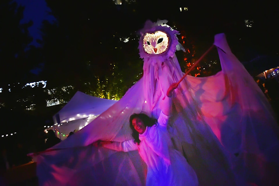 Tahina Awan with Candy Bones Theatre wanders around Memorial Peace Park as an owl during Celebrate the Night festivities on Friday. (Colleen Flanagan/The News)